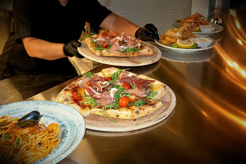 Pizza på trätallrik i kvällsljus